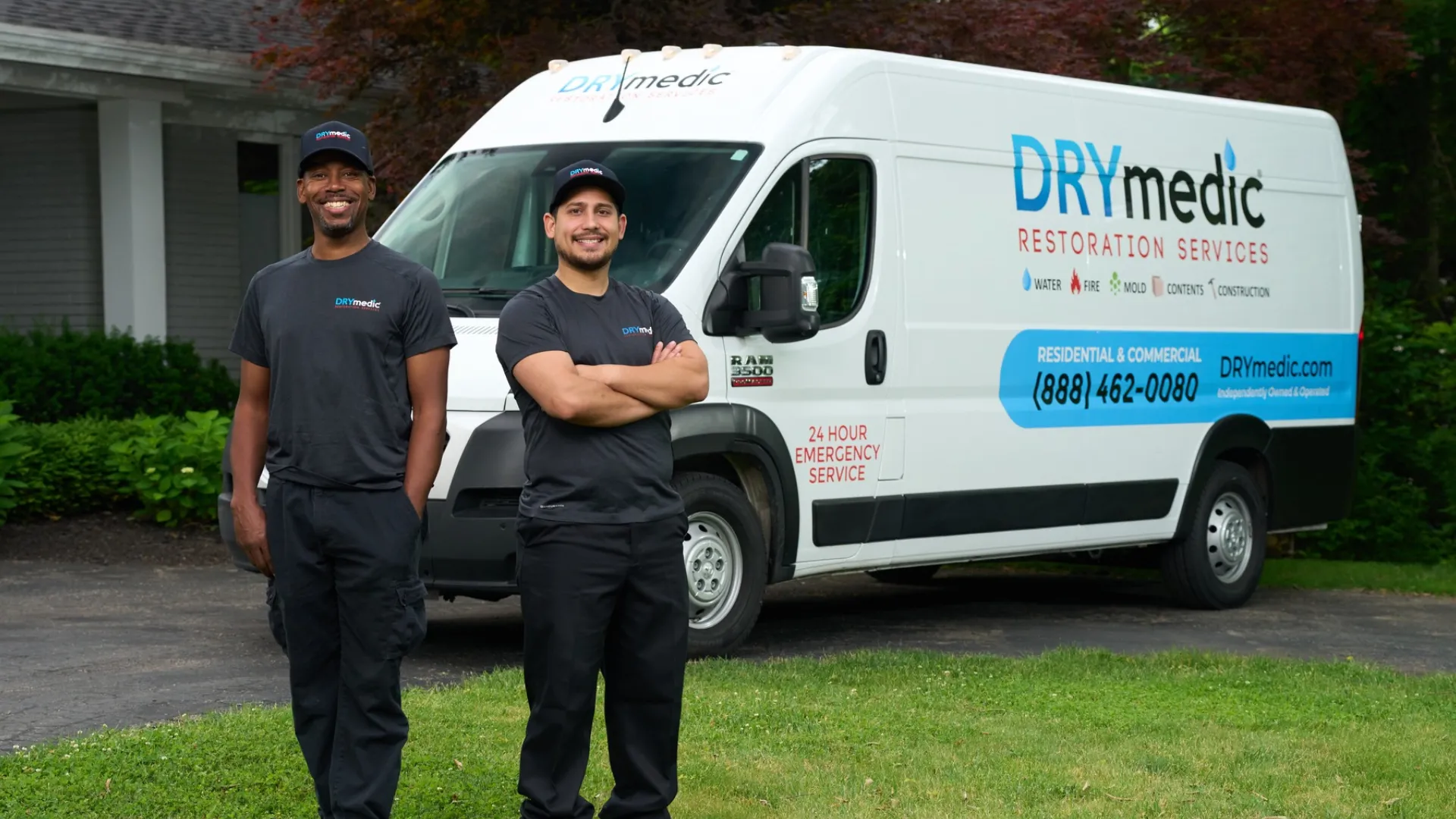 Photo of two DRYmedic team members standing in front of branded vehicle